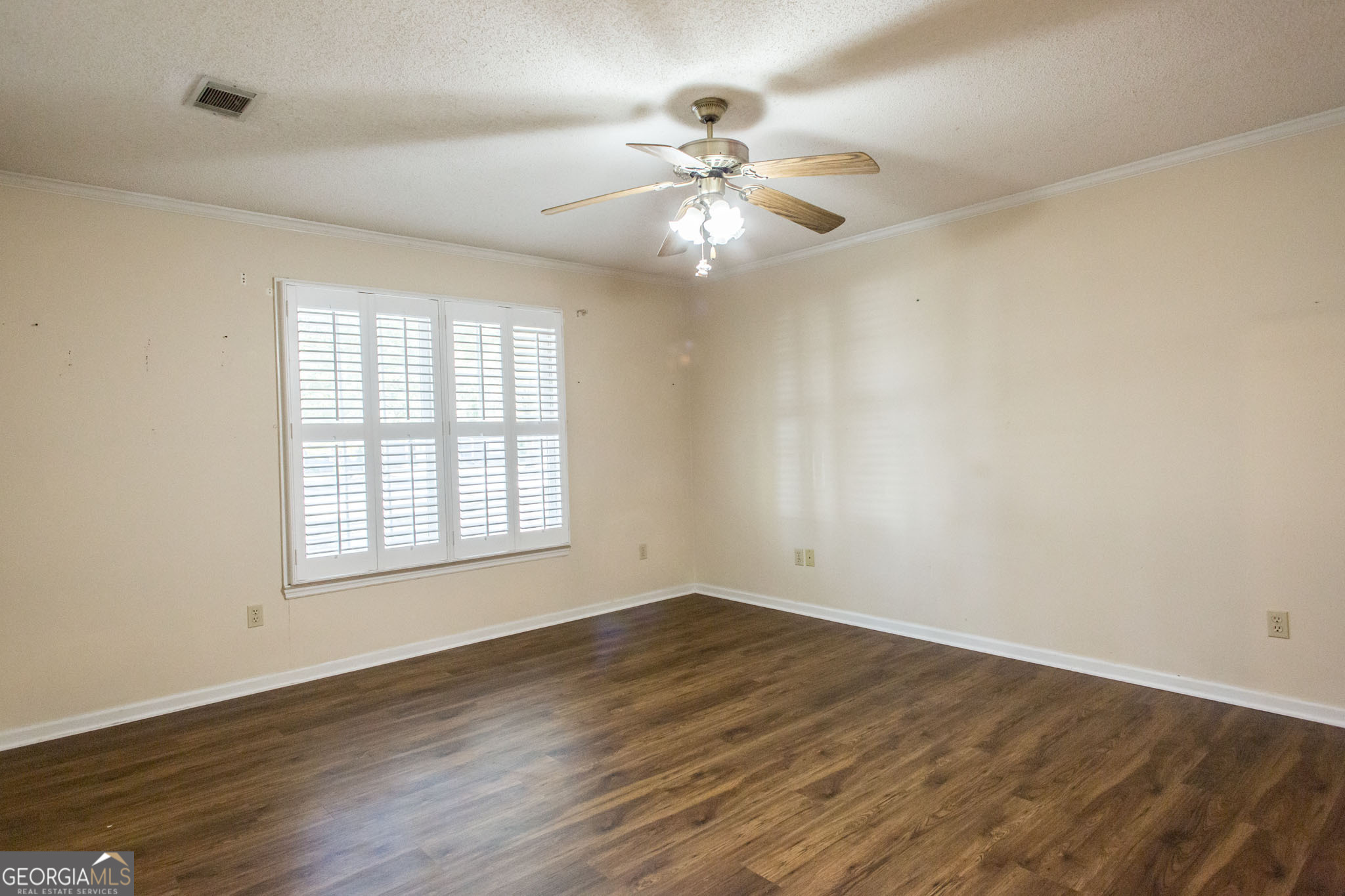2959 Chadwick Drive Waycross, GA 31501 - Photo 43 of 52 an empty room with wooden floor fan and windows