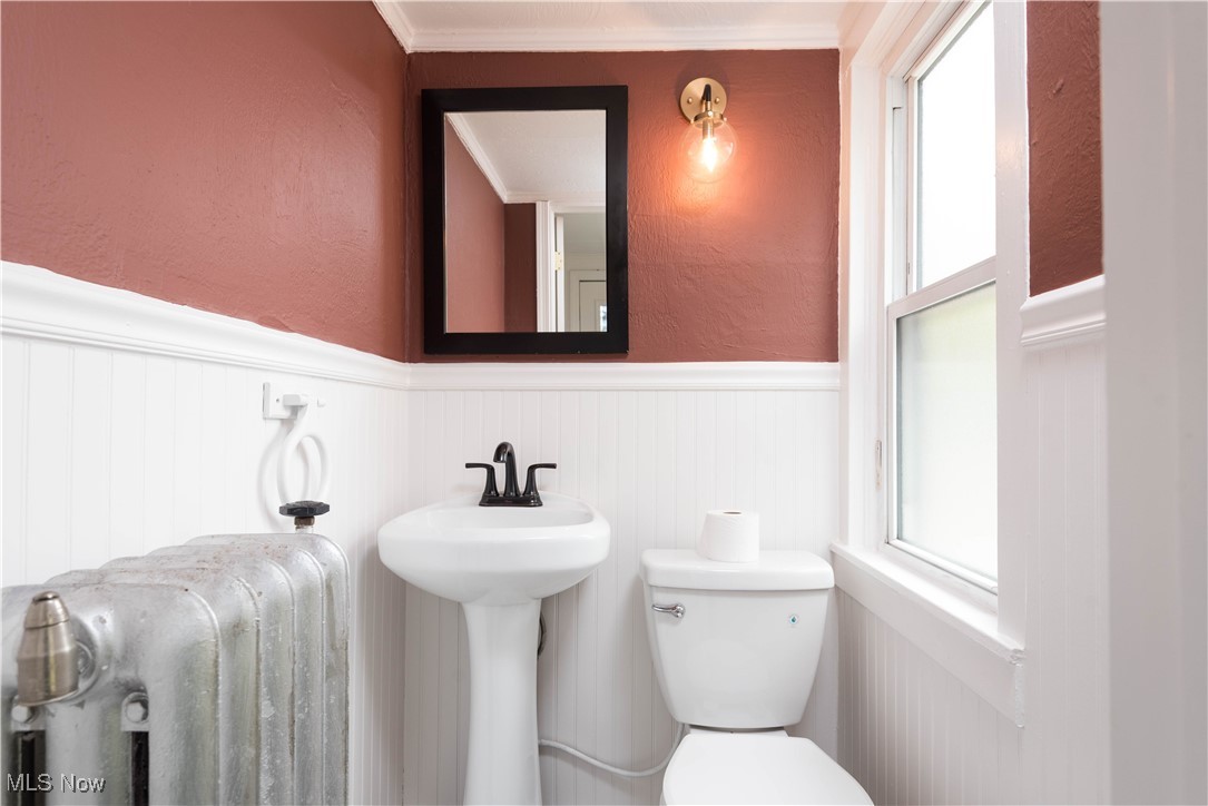 7003 Brecksville Road Independence, OH 44131 - Photo 24 of 35 Half bathroom with a textured wall, a wainscoted wall, radiator heating unit, and ornamental molding