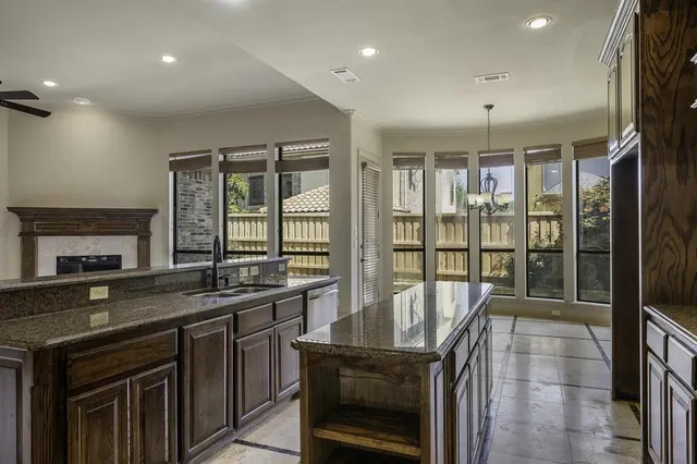 a view of an empty room with a fireplace and a ceiling fan