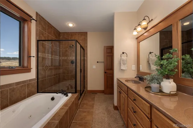 a spacious bathroom with a tub sink and mirror