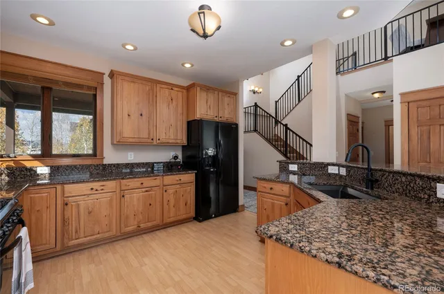 a kitchen with stainless steel appliances granite countertop a sink stove and refrigerator