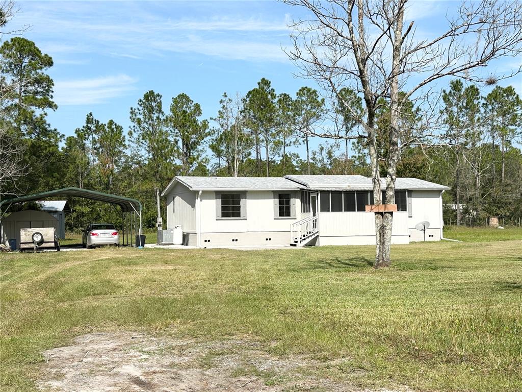 4318 Walnut Avenue Bunnell, FL 32110 - Photo 1 of 1 a view of a house with a big yard and large trees