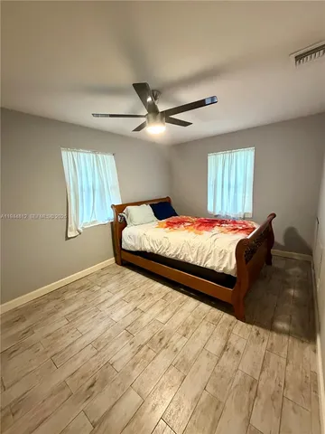 a bedroom with a bed and a ceiling fan