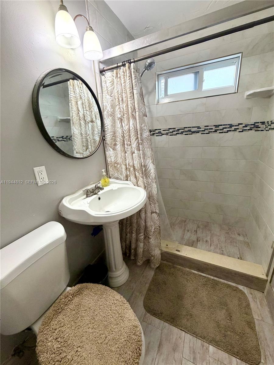 935 Churchill Road West Palm Beach, FL 33405 - Photo 6 of 10 a bathroom with a sink toilet a mirror and shower