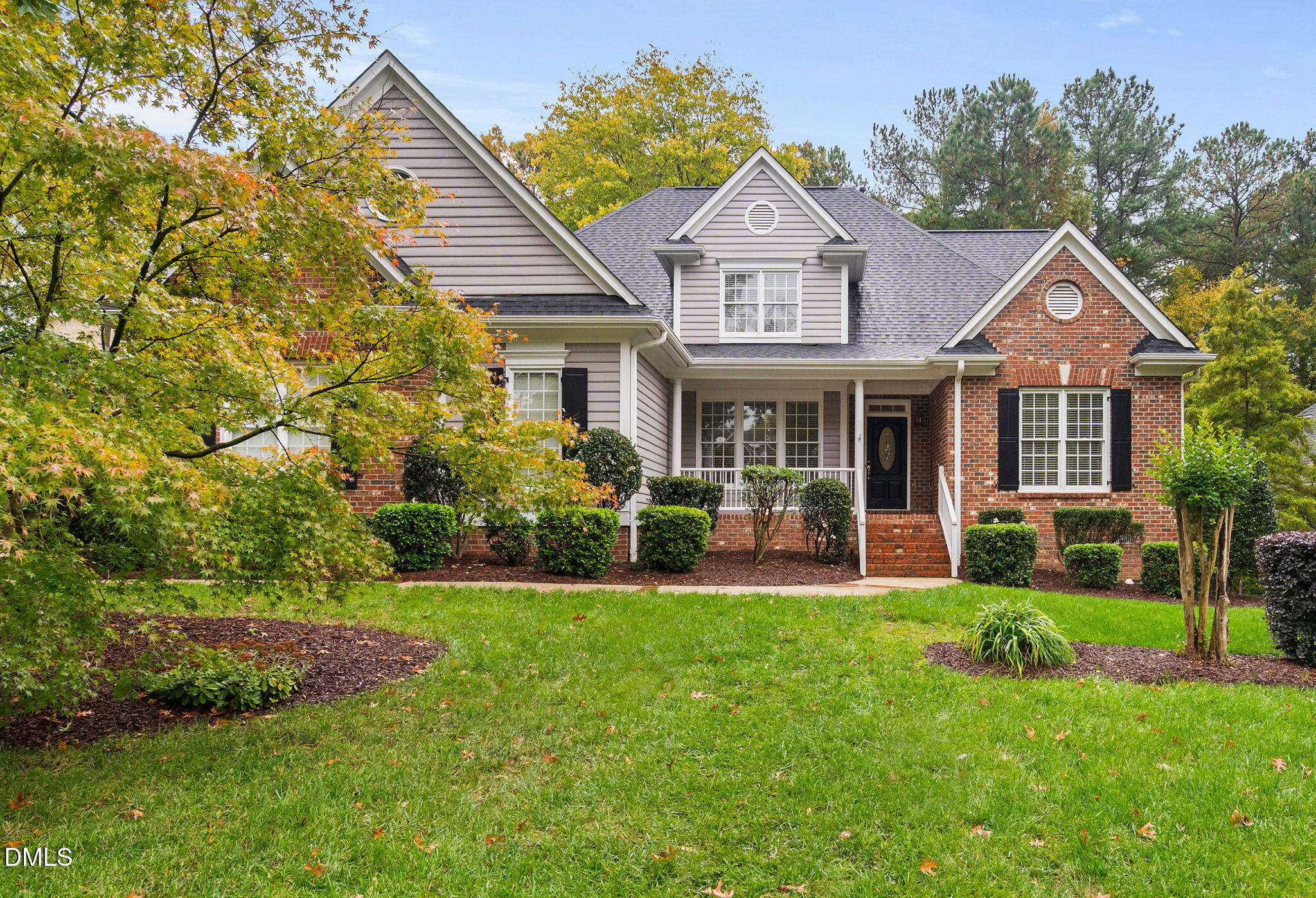 a front view of a house with a yard and green space