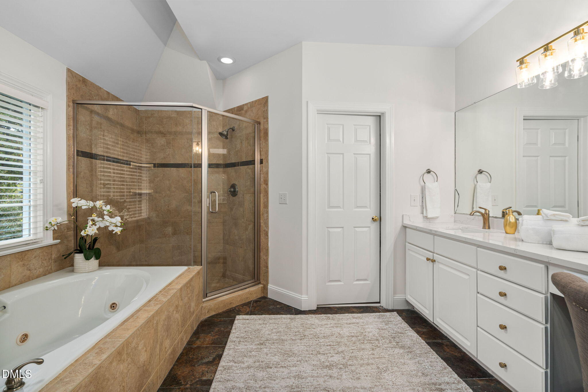 310 Hogans Valley Way Cary, NC 27513 - Photo 29 of 49 a bathroom with a tub a sink and mirrors