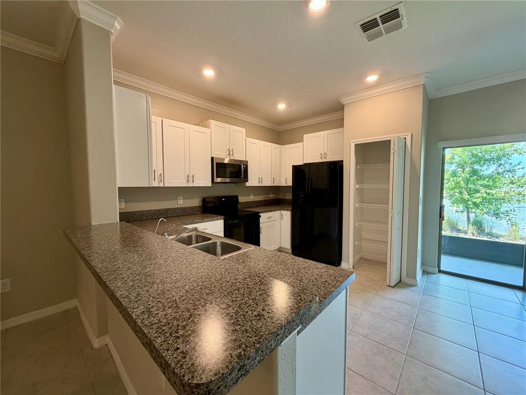 11826 Dumaine Valley Road Riverview, FL 33579 - Photo 11 of 54 a kitchen with stainless steel appliances granite countertop a sink and a refrigerator