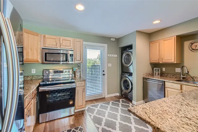 a kitchen with granite countertop a stove and a refrigerator