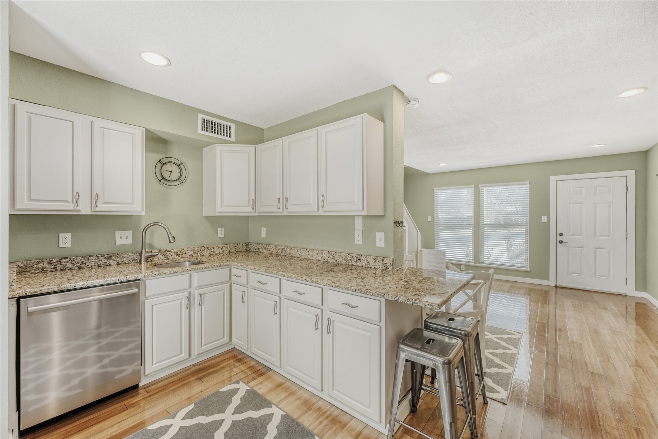 2000 Lightsey Road, Unit 3 Austin, TX 78704 - Photo 6 of 28 Kitchen with stainless steel dishwasher, light stone countertops, light wood-type flooring, white cabinetry, and recessed lighting