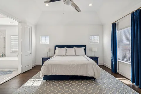 a bedroom with a bed and a walk in closet with wooden floor