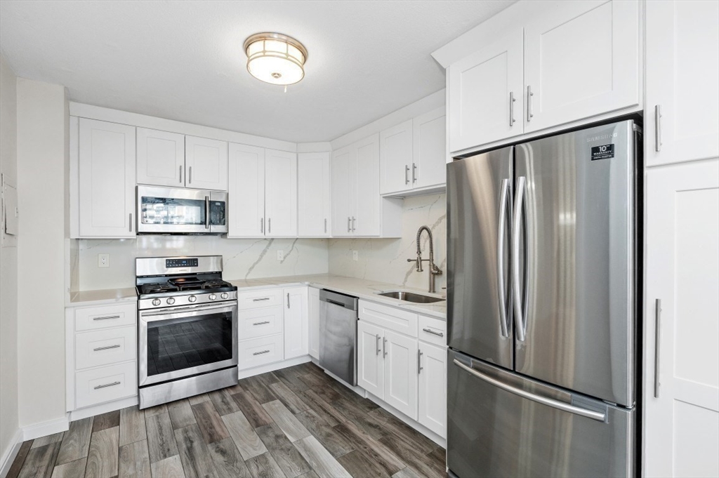 a kitchen with cabinets stainless steel appliances and a refrigerator