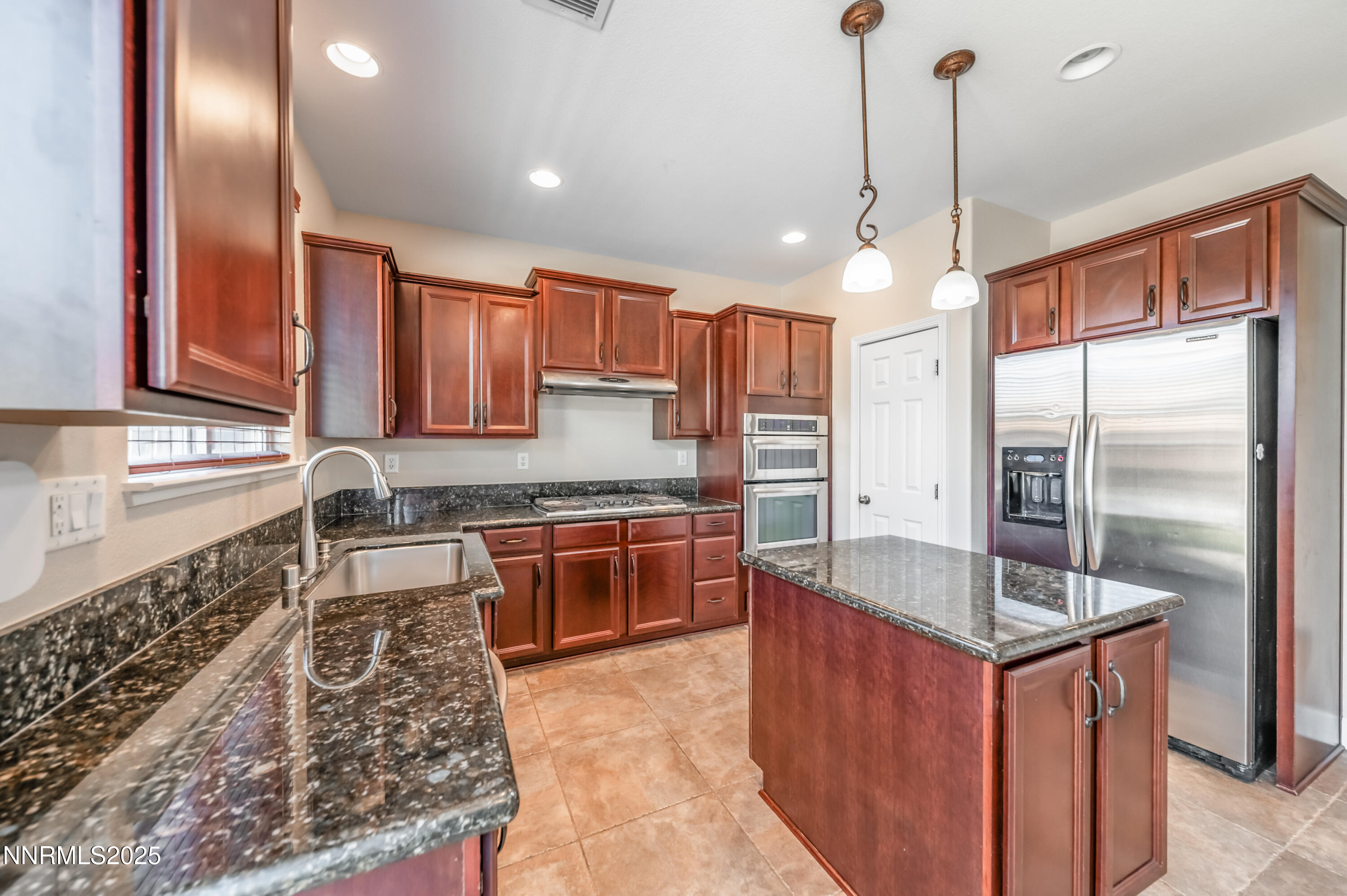 1935 Glacier Meadow Drive Reno, NV 89521 - Photo 5 of 20 a kitchen with stainless steel appliances granite countertop a sink refrigerator and cabinets