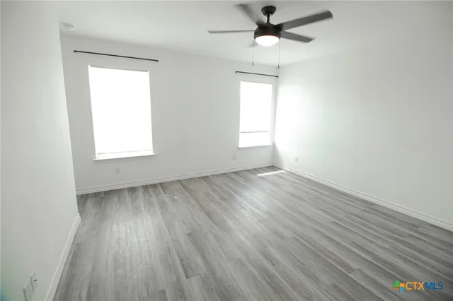 wooden floor in an empty room with a window