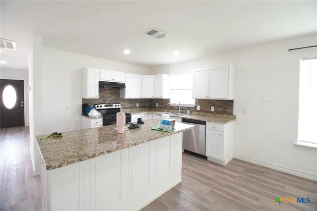 a kitchen with sink a microwave and cabinets