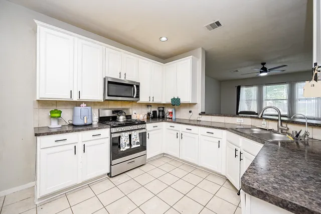 a kitchen with granite countertop white cabinets and white appliances