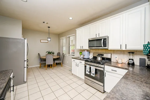 a kitchen with a sink a stove and white cabinets