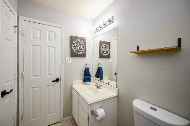 a bathroom with a sink a toilet and a mirror