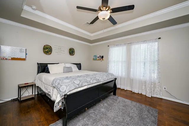 a bedroom with a bed and wooden floor