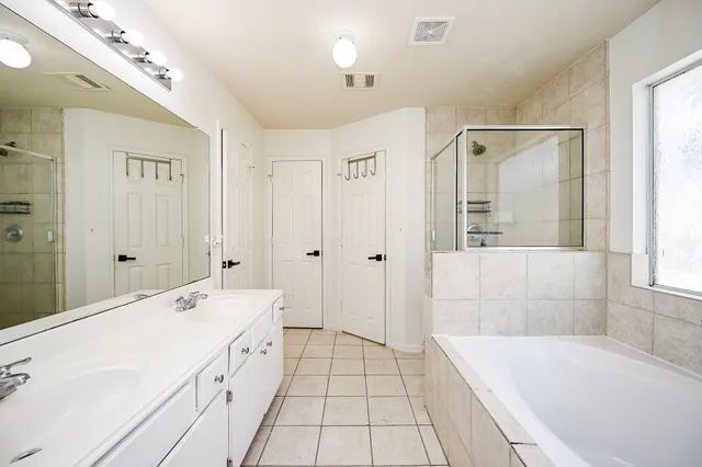 a spacious bathroom with a tub sink and shower
