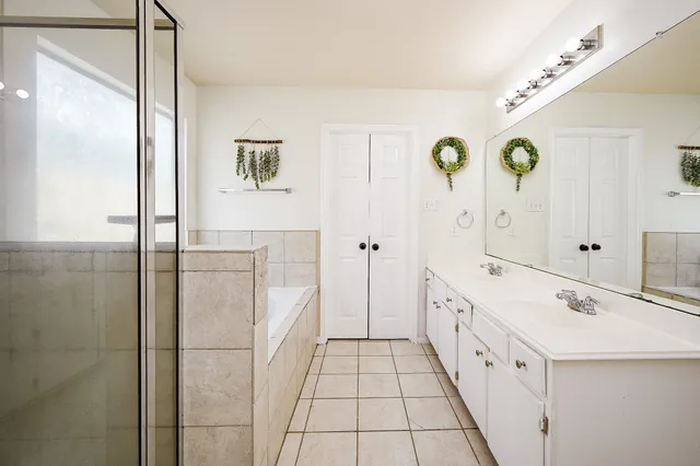 a spacious bathroom with a double vanity sink and a mirror
