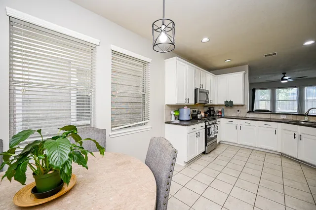 a kitchen with stainless steel appliances furniture and a large window