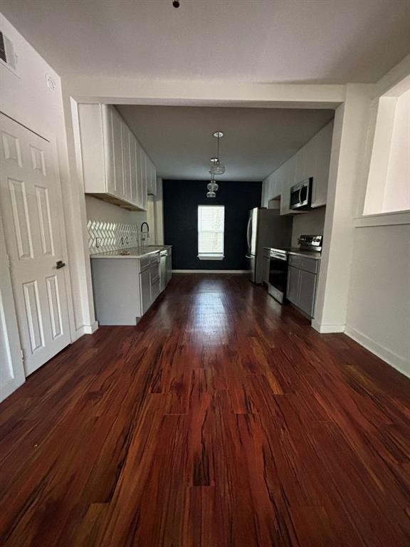 2505 May Street Fort Worth, TX 76110 - Photo 18 of 19 a kitchen with a wooden floor and electronic appliances