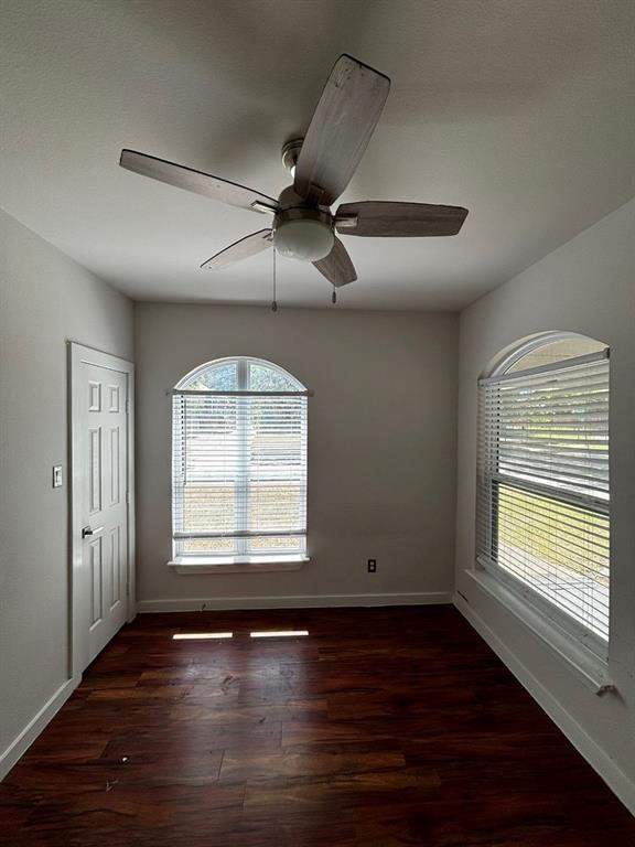 2505 May Street Fort Worth, TX 76110 - Photo 2 of 19 an empty room with wooden floor chandelier fan and windows
