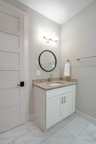 a bathroom with a granite countertop sink and a mirror