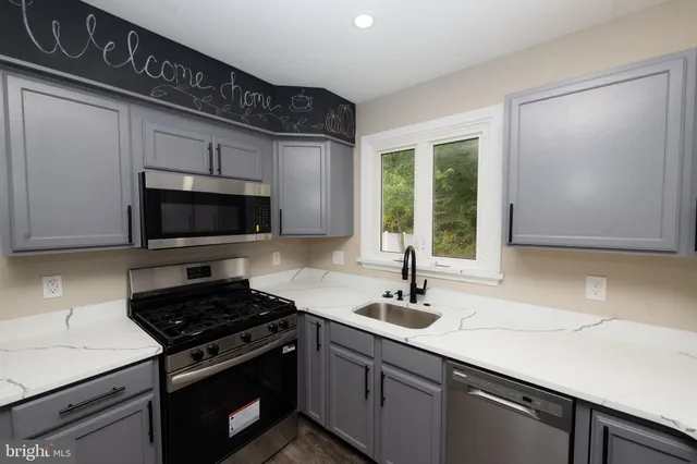 a kitchen with stainless steel appliances a sink stove and microwave