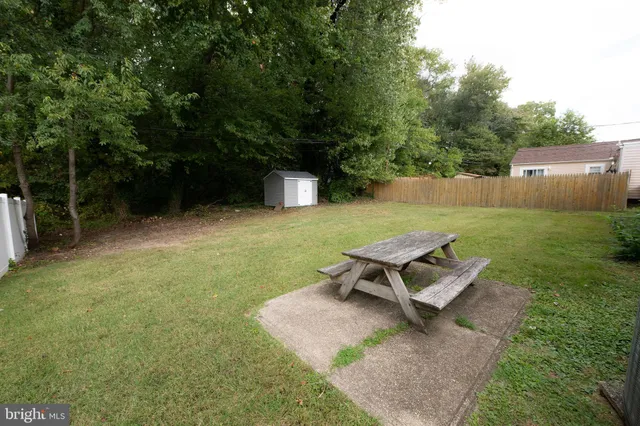 a wooden bench sitting in the middle of a yard