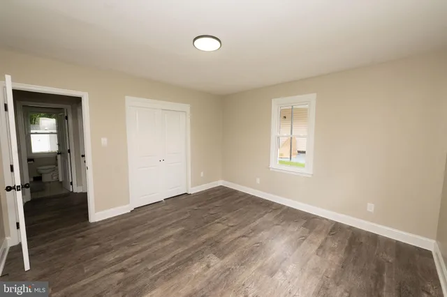 an empty room with wooden floor and a window