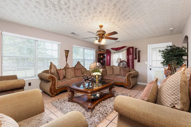 a living room with furniture ceiling fan and a window