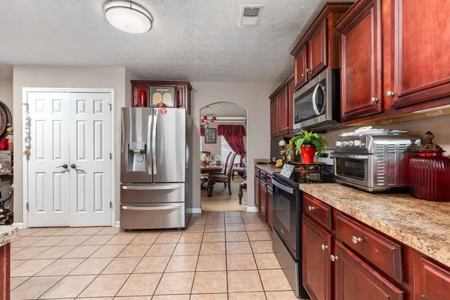 a kitchen with stainless steel appliances granite countertop a refrigerator and a stove top oven