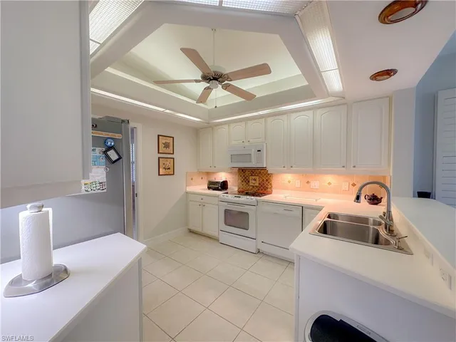 a kitchen with a sink a stove top oven and cabinets
