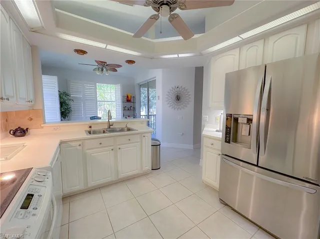 a kitchen with a refrigerator sink and cabinets