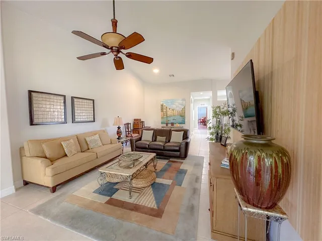 a living room with furniture a flat screen tv and a window