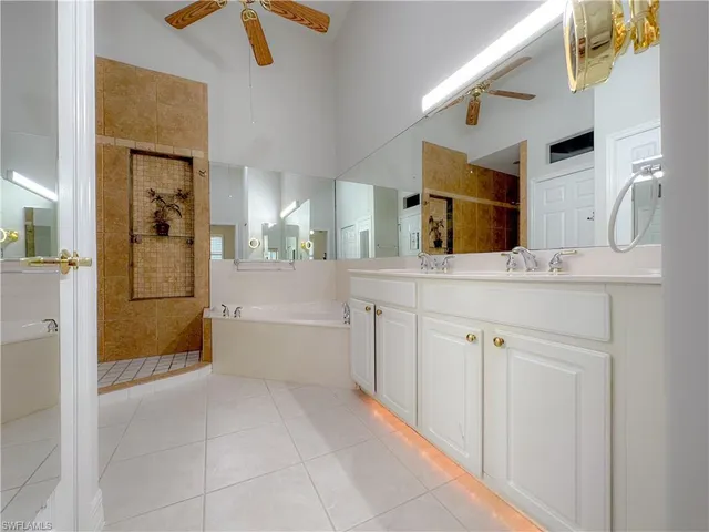 a bathroom with a granite countertop sink mirror and bathtub