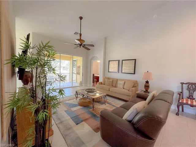 a living room with furniture a chandelier and a window