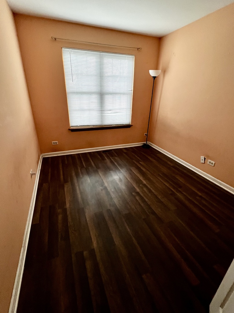 613 Sutton Court Wheeling, IL 60090 - Photo 18 of 36 en empty room with wooden floor and windows