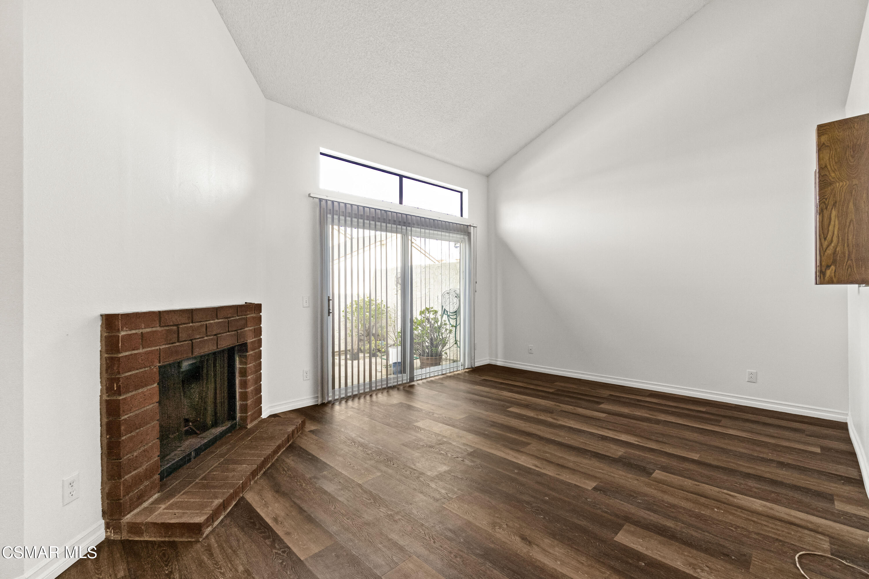 5133 Perkins Road Oxnard, CA 93033 - Photo 10 of 30 an empty room with wooden floor fireplace and windows