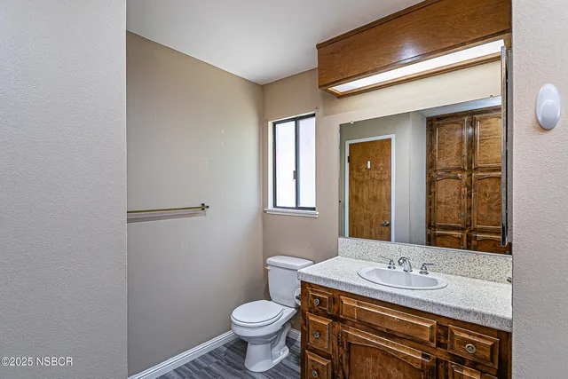 a bathroom with a granite countertop toilet sink and mirror