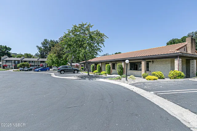 a view of a house with a small yard and potted plants