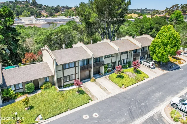 an aerial view of a house with garden space and street view