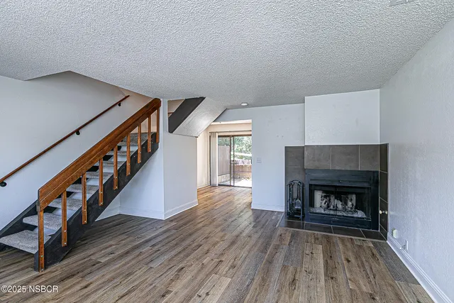 a living room with wooden floors and a fireplace