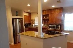 a kitchen with stainless steel appliances granite countertop a refrigerator and a sink