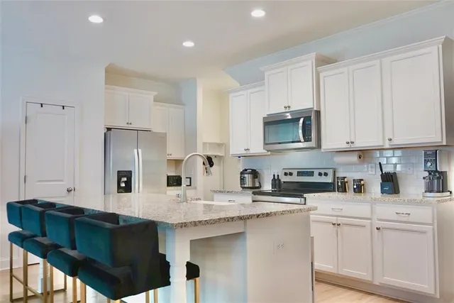 a kitchen with stainless steel appliances granite countertop a stove a sink dishwasher and a refrigerator with wooden cabinets