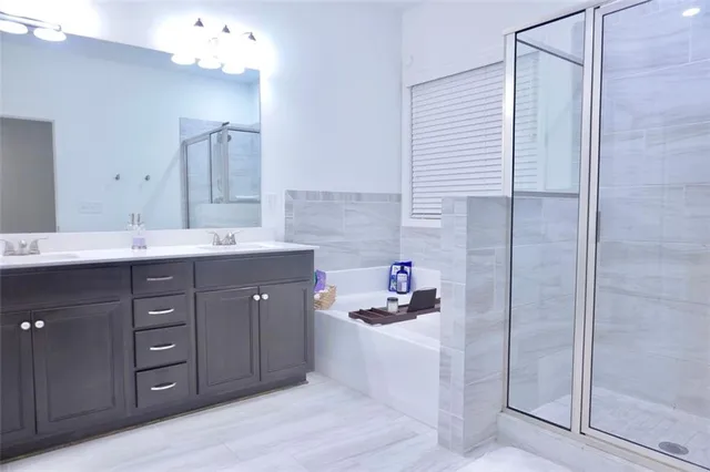 a spacious bathroom with a sink a shower and a mirror