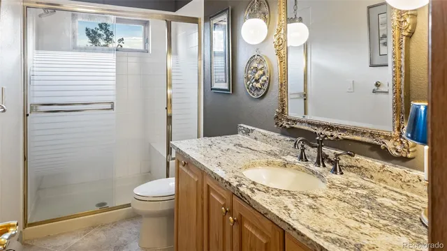 a bathroom with a granite countertop sink toilet and shower