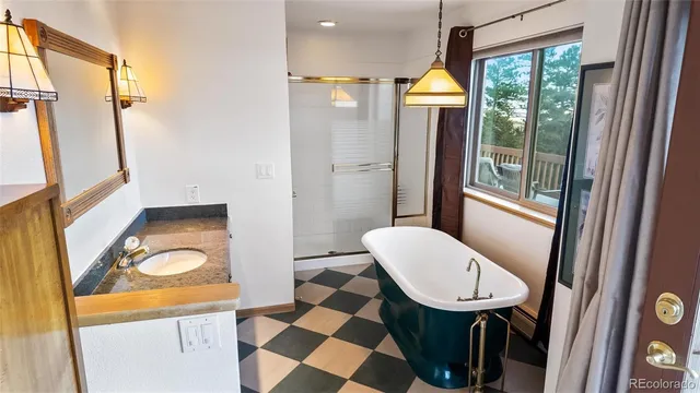 a bathroom with a sink a toilet a mirror and shower