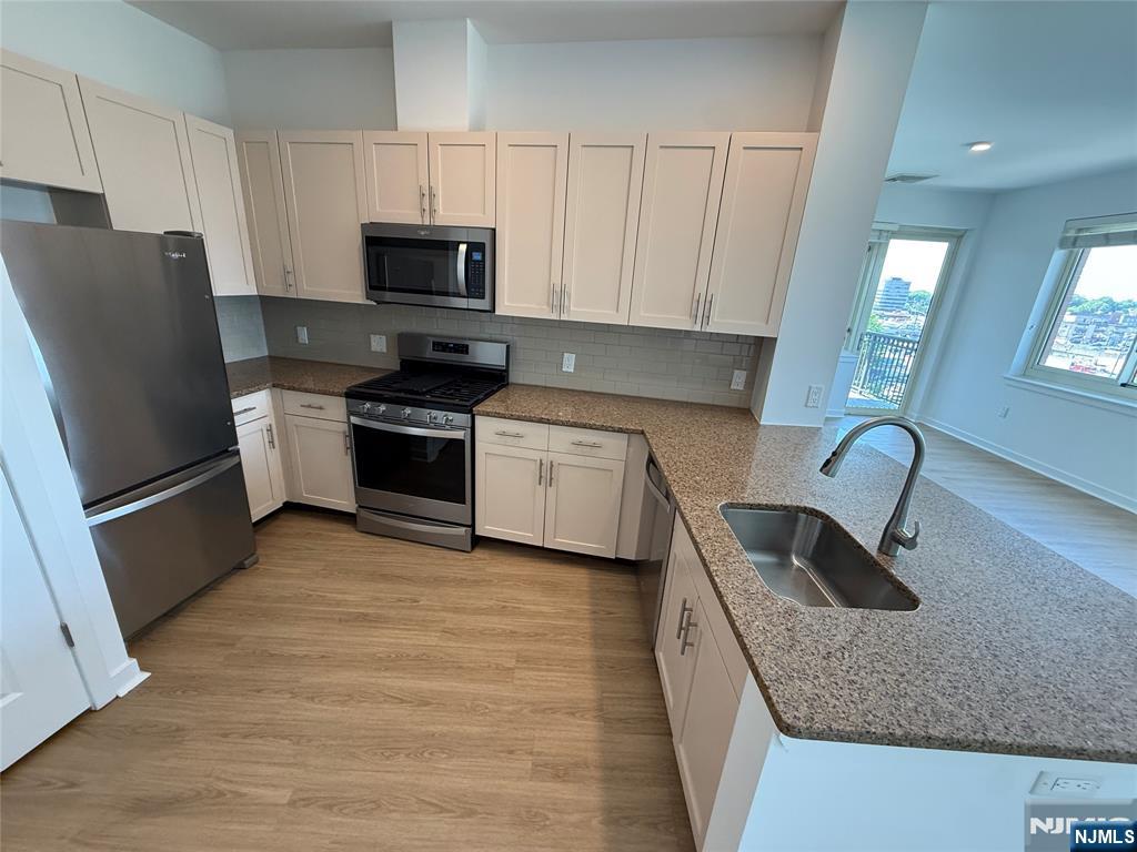 2050 North Central Road, Unit 710 Fort Lee, NJ 07024 - Photo 2 of 21 a kitchen with granite countertop a refrigerator stove and sink